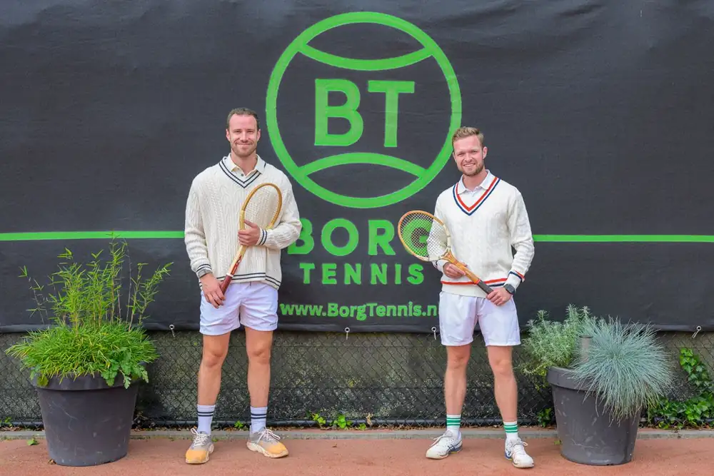 Hoofdtrainers Maikel en Julian in witte tenues met houten rackets