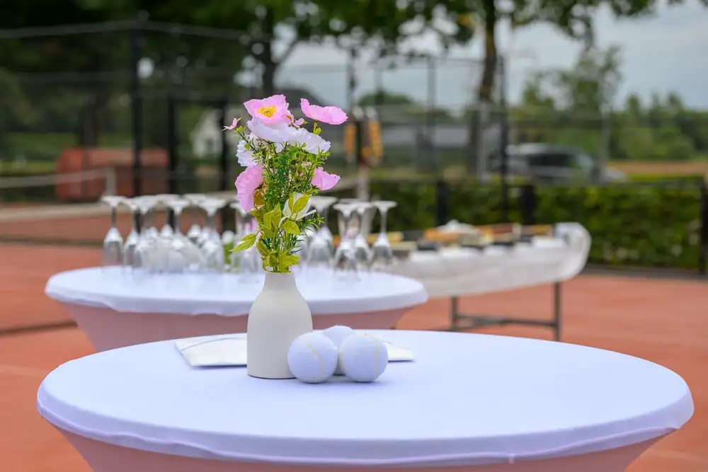 Statafel met bloemen en witte tennisballen