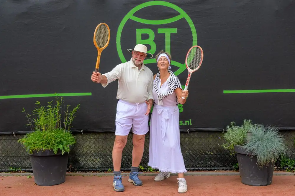 Deelnemers in vintage tennisoutfit met houten rackets